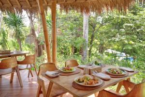 Bila Penida Resort & Farm في نوسا بينيدا: طاولة خشبية عليها أطباق طعام