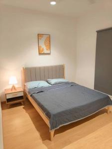 a bedroom with a bed and a night stand with a lamp at Maya Bay Gamuda Cove Splash Mania near KLIA and Cyberjaya in Pulau Kempas
