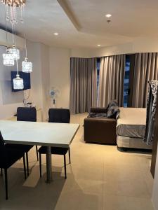 ein Wohnzimmer mit einem Bett und einem Tisch und Stühlen in der Unterkunft Tambuli Seaside Residences Buyong Road Maribago Lapu Lapu City in Cogon