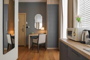 eine Küche mit einem Tisch mit Stühlen und einem Spiegel in der Unterkunft iCheck inn Residence soi 2 in Bangkok