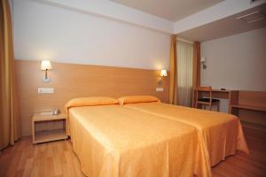 a bedroom with a large bed with an orange bedspread at Hotel Windsor in Santiago de Compostela