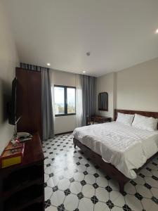 a bedroom with a bed and a desk and a television at Nhã Hotel in Phan Rang–Tháp Chàm
