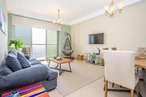 a living room with a blue couch and a table at Contemporary Full Ocean View Apartment in Ras al Khaimah