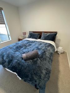 基督城Bryndwr Accommodation的一间卧室配有一张带蓝色棉被的大床 更多24张照片