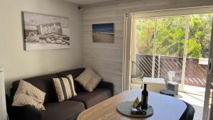 a living room with a couch and a table at Duplex carcans plage in Carcans