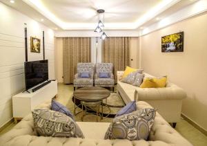 a living room with two couches and a tv at Luxurious 3 Bed 4 Bath Condo in Nairobi