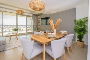 een eetkamer met een houten tafel en stoelen bij Oceanfront Coastal Apartment in Ras al Khaimah