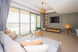 een woonkamer met een bank en een tv bij Oceanfront Coastal Apartment in Ras al Khaimah
