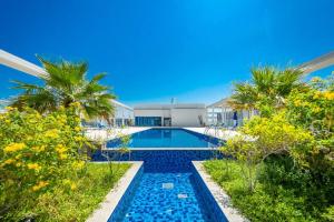 een zwembad met palmbomen voor een gebouw bij Oceanfront Coastal Apartment in Ras al Khaimah