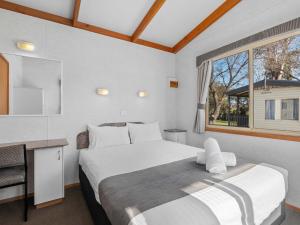 a bedroom with a large bed and a window at Canberra Holiday Village in Canberra