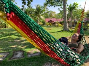 una donna sdraiata su un'amaca in un parco di palanas white sand beach resort a Himensulan