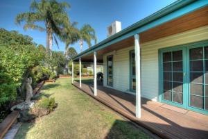 a porch of a house with palm trees at Wandew - Echuca Holiday Homes in Echuca