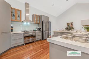 a large kitchen with stainless steel appliances and wood floors at Winbi Retreat in Moama