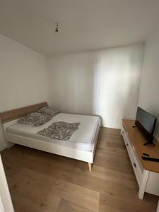 a white bedroom with a bed and a desk at Appartement moderne centre ville in Saint-Dizier