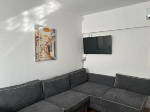 a living room with a couch and a flat screen tv at Apartament Kali in Ahtopol