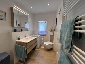 a white bathroom with a sink and a toilet at Ferienwohnung Nestblick in Weilburg +15 photos