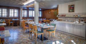 a restaurant with tables and chairs and a counter at Hôtel Mont-Brison in Briançon