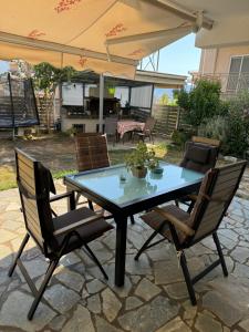 a patio table with chairs and an umbrella at Home Garden in Igoumenitsa