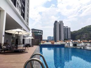 a swimming pool with chairs and an umbrella on a building at Le Quadri Kuala Lumpur By UCSI Hotels in Kuala Lumpur