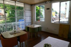 a room with two tables and a large window at City Nest Inn in Kandy +20 photos