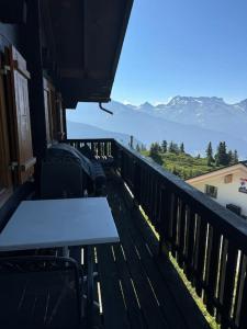 een balkon met een tafel en uitzicht op de bergen bij Chalet Hofathoru in Belalp