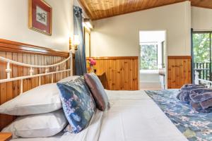 a bedroom with a large bed and a window at Montville Country Cabins in Montville