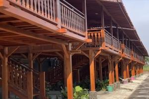 ein Holzgebäude mit Balkonen darauf in der Unterkunft Argo limo Cottage Syariah Magelang in Tanayung + 27 Fotos