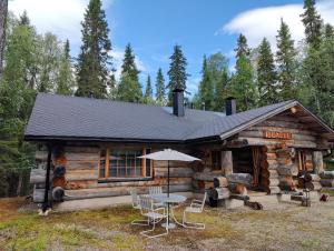 a log cabin with a table and chairs in front of it at Isokelo Log Apartments in Salla