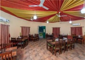 une salle à manger avec tables et chaises et un plafond dans l'établissement Arise Ethnic Village Resort - Manesar Bilaspur, à Gurgaon