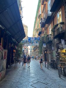 un gruppo di persone che camminano lungo una strada di Spinelli house a Napoli