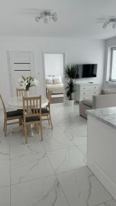 a white living room with a table and chairs at Apartament Grójec in Grójec
