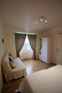 a bedroom with two beds and a window at L'ESCAPADE BIGOUDENE - maison 300m de la plage in Tréffiagat