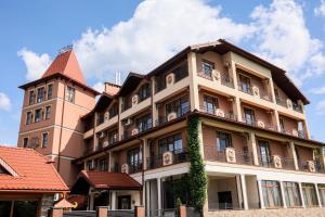 un grande edificio con una torre e viti di Ferdinand a Mukačevo