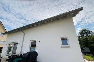 a white house with a cloudy sky in the background at Deluxe in Burladingen