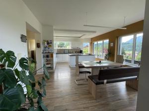 a living room with a table and a kitchen at Modernes Haus mit super Aussicht in Windischgarsten