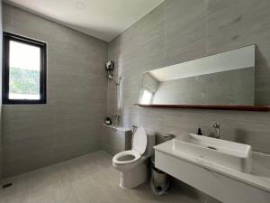 a bathroom with a toilet and a sink and a mirror at Brown Cotton Villa Khanom in Khanom +16 photos