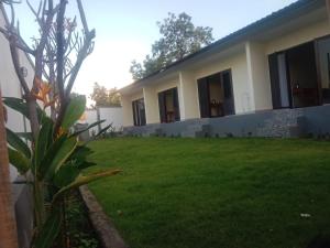 a house with a lawn in front of it at Me'Sari Guest House in Karangasem