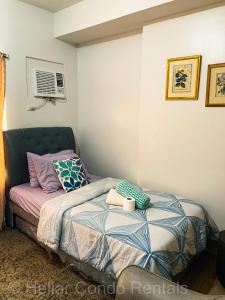 a bedroom with a bed with a pillow and a window at HELLAR Condo Rentals in Bacolod +105 photos