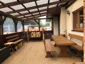 a patio with a wooden table and benches on a building at Ferienwohnung Zum Eduardstal in Reisenbach
