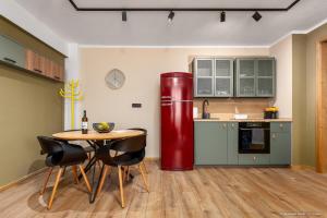 a kitchen with a red refrigerator and a table at Apartament Nordic 2 in Gura Humorului