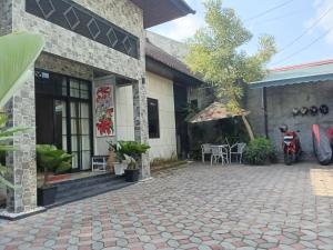 a house with a patio and a table and a tree at 24StaycationHome in Yogyakarta