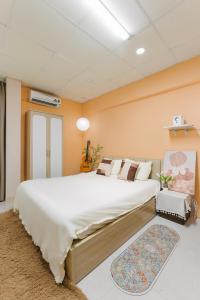 a bedroom with a large white bed and a rug at Ann's Home in Hanoi