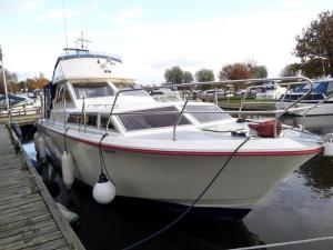 a white boat is docked at a dock at Escapade en Bateau VINTAGE terrasse mini spa option payante in Seurre
