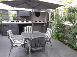 a patio with a table and chairs and an umbrella at The Treehouse by Airlie in Nairn