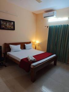 a bedroom with a large bed with a green curtain at Ac 3 Bedroom House Mysore in Mysore