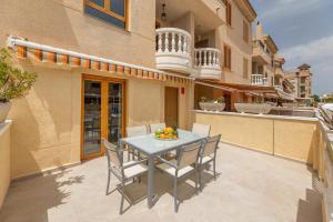 a patio with a table and chairs on a balcony at Under the Spanish Sun - House on the beach in Santa Pola