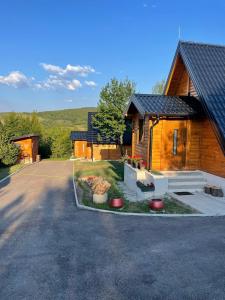 a house with a driveway next to a building at Chalet Licina - Bjelašnica in Klanac