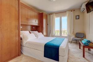 a bedroom with a bed and a chair and a window at Villa Hestia Calvi - Maison avec piscine in Calvi