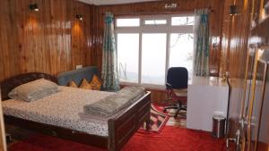 a bedroom with a bed and a large window at Tranquil Retreat Homestay in Ghum