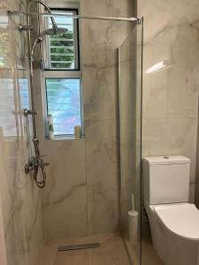 a bathroom with a glass shower with a toilet at Andromeda Shell House in Pefkochori +29 photos